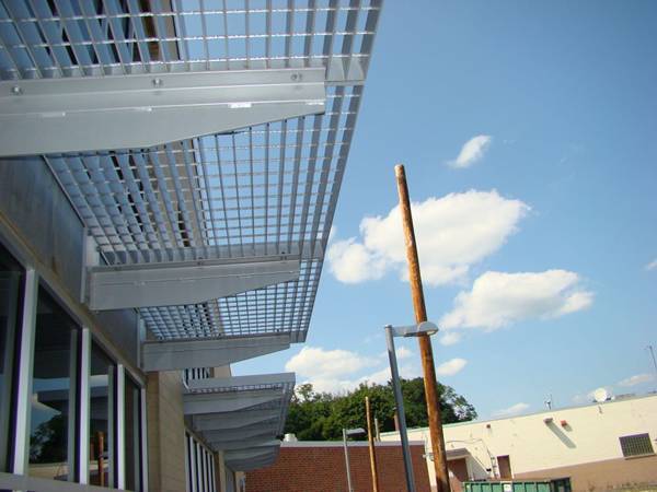 Aluminum gratings serve as sun shades against the blue sky.