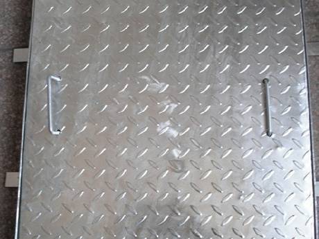 A square compound steel grating with eight bars on the four sides placed on the ground.