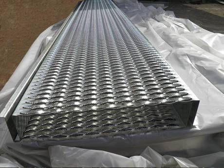 Two large diamond-strut safety grating planks placed on plastic film.