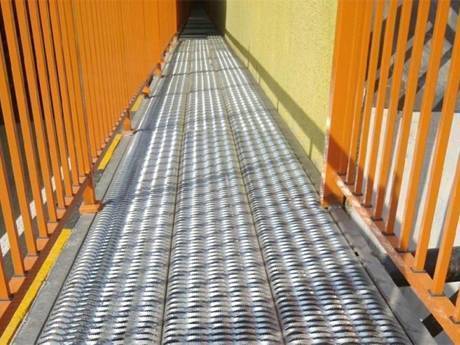 A diamond-strut safety grating is used as walkway for people to walk.