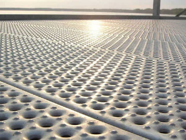 The perforated steel grating is installed on the offshore platform.