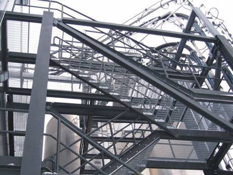 The grey press-locked steel grating used as stairs.