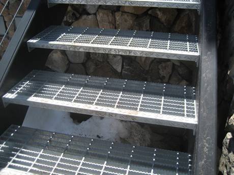 Serrated welded steel grating used as stair tread to improve safety.