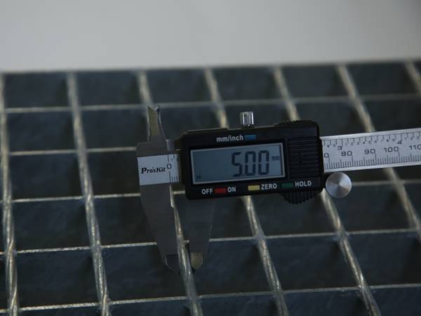 A worker is testing the cross bar diameter of steel bar grating.