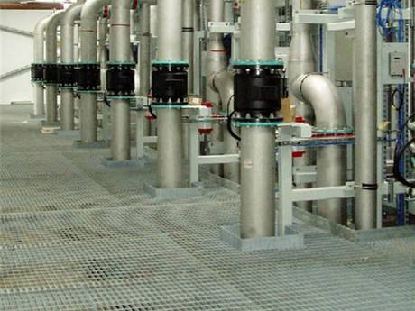 The steel grating floor above the ground, surrounding metal pipes in chemical plant.