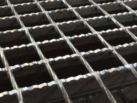 A welded steel grating with serrated surface.