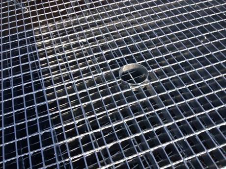 There is steel grating with a small hole in the middle.