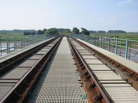 Steel grating bridge walkway across the wetland.