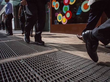 Many people are walking in the steel grating walkway of walking street.