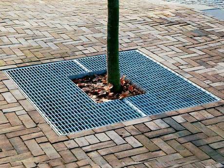 A tree cover steel grating is installed at a tree in plaza.