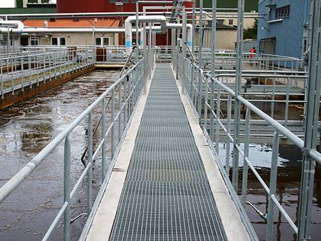 Sidewalk with handrails crossing the waste water area.